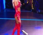 WWE - Carmella in red outfit standing over Sasha Banks from carmella in bikini