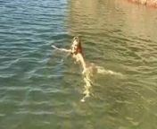 Cute young brunette strips by the water and goes skinny dipping from water strip